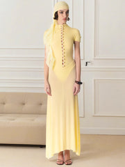 Woman wearing a yellow dress with a matching headscarf in an elegant room.