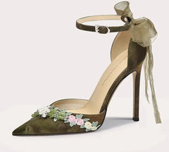 High-heeled shoe with floral decorations on a light gray background