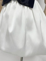 White skirt with a black waistband on a mannequin.