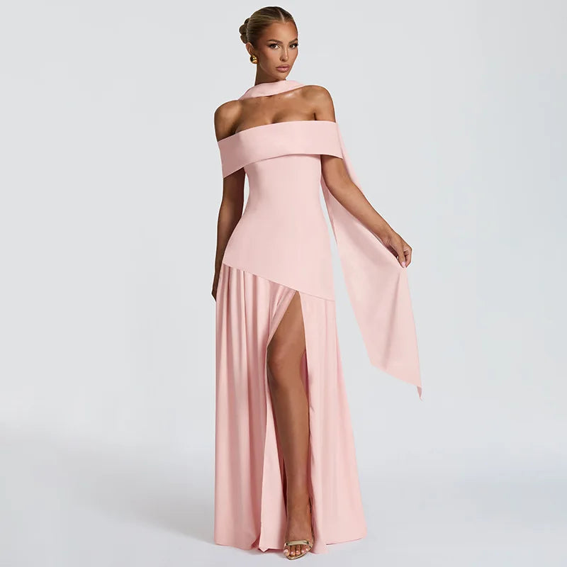 Woman wearing a pink off-shoulder gown with a slit on a light gray background