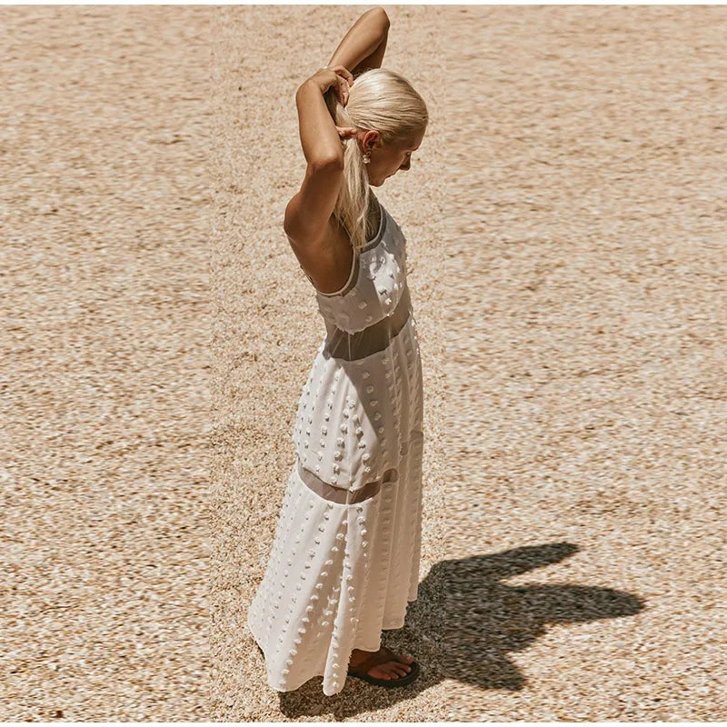 Woman in a white dress standing on a textured beige surface