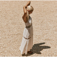Woman in a white dress standing on a textured beige surface