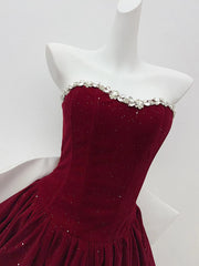 Red strapless dress with embellishments on a mannequin against a white background