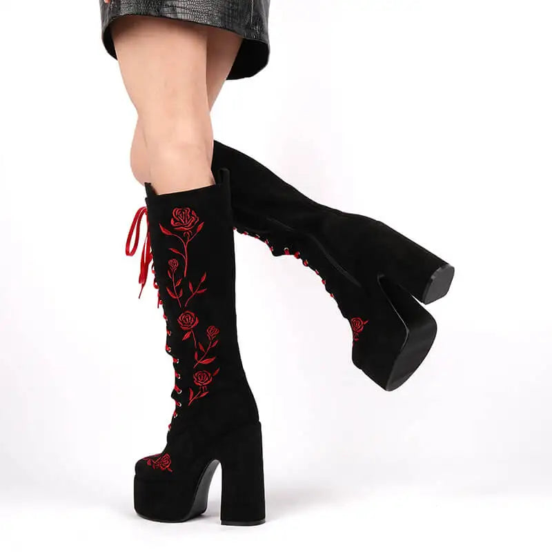 Black platform boots with red floral embroidery on a white background