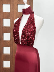 Red sequin dress on a mannequin against a wooden panel background