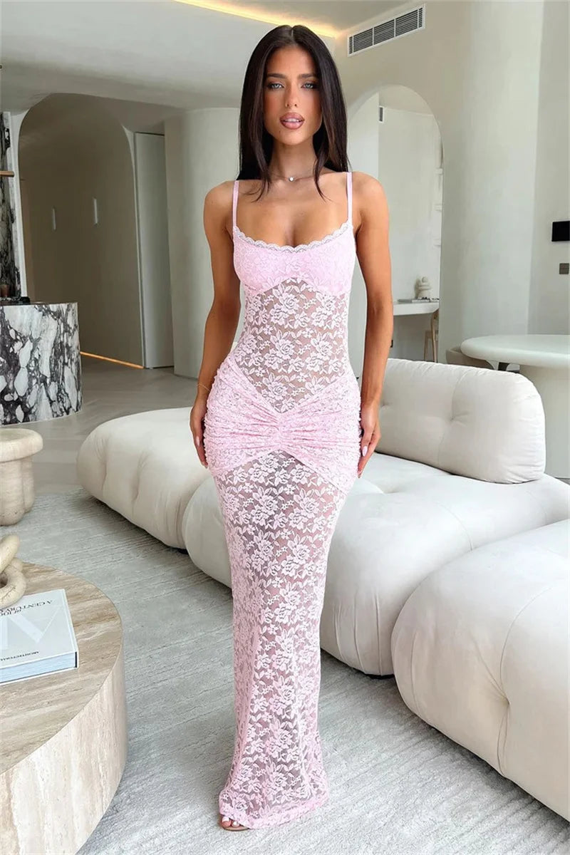 Woman in a pink lace dress sitting on a white couch in a modern living room.