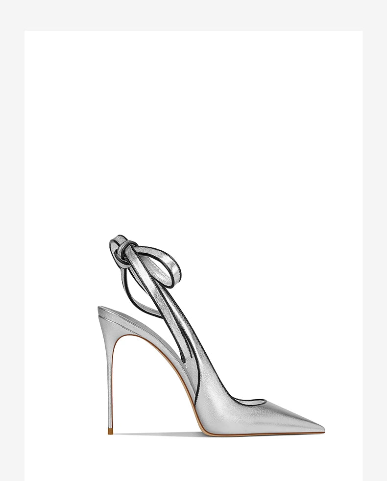 Silver high-heeled shoe with a bow on a white background
