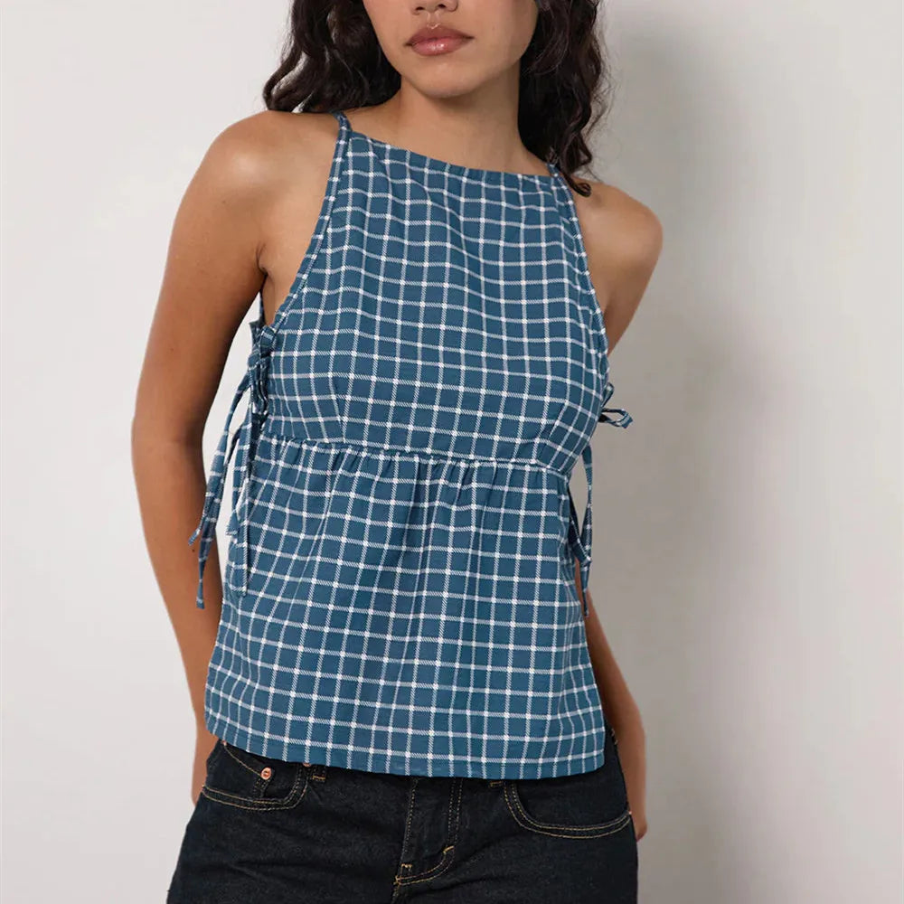 Woman wearing a blue checkered halter top against a plain background