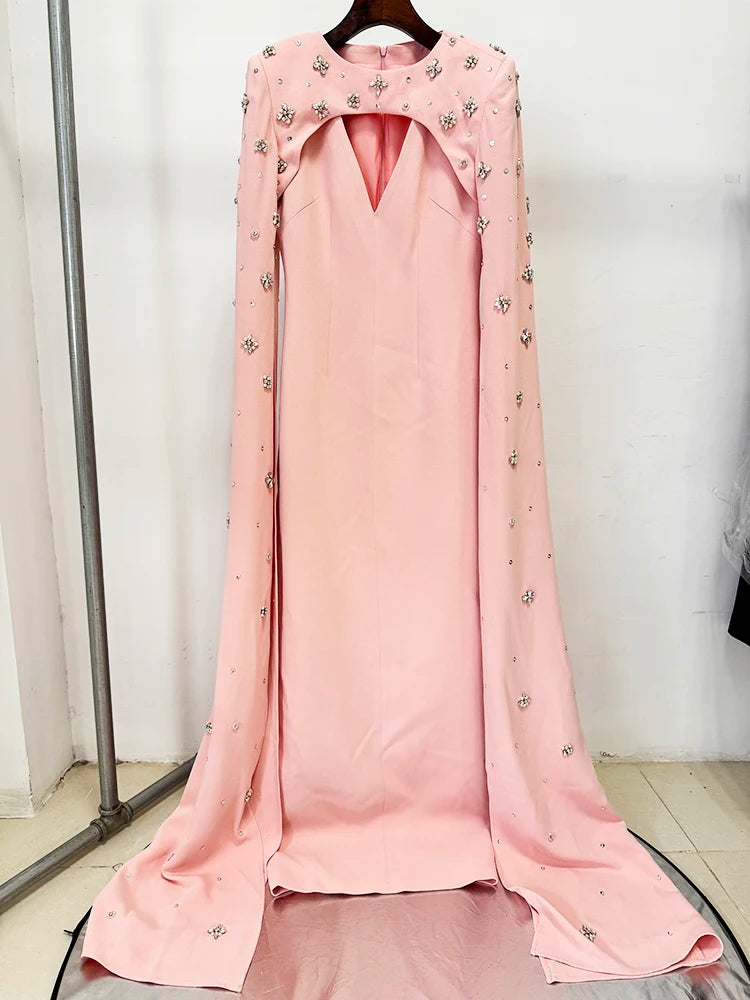 Pink maxi dress with beaded cape sleeves on a hanger