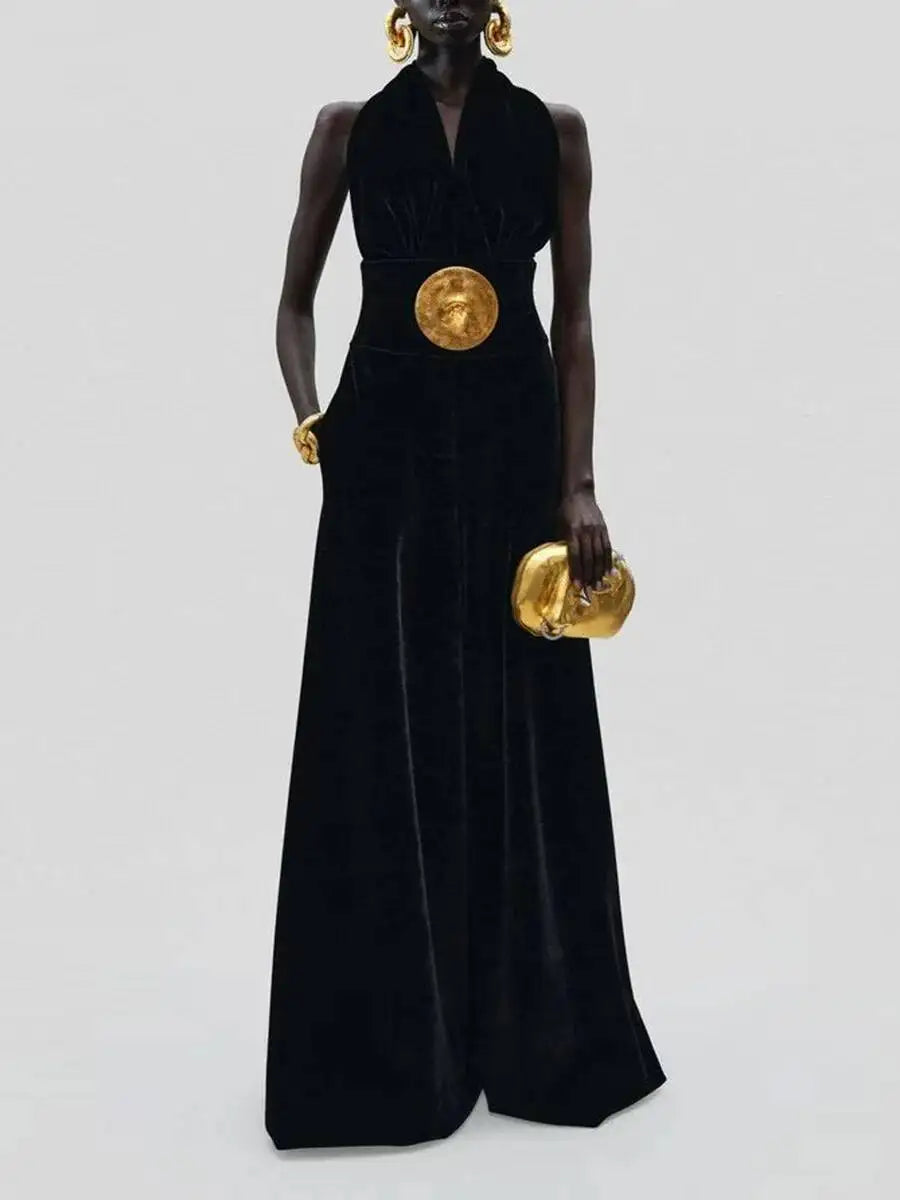Person wearing a black jumpsuit with gold accents on a white background