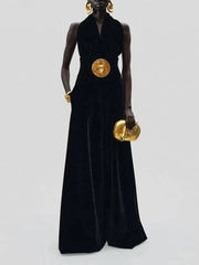 Person wearing a black jumpsuit with gold accents on a white background