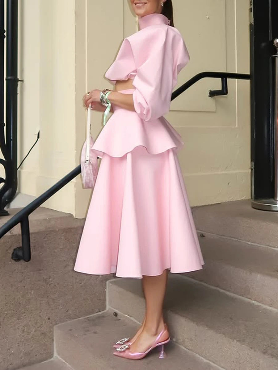 Person wearing a pink dress stepping out of a building