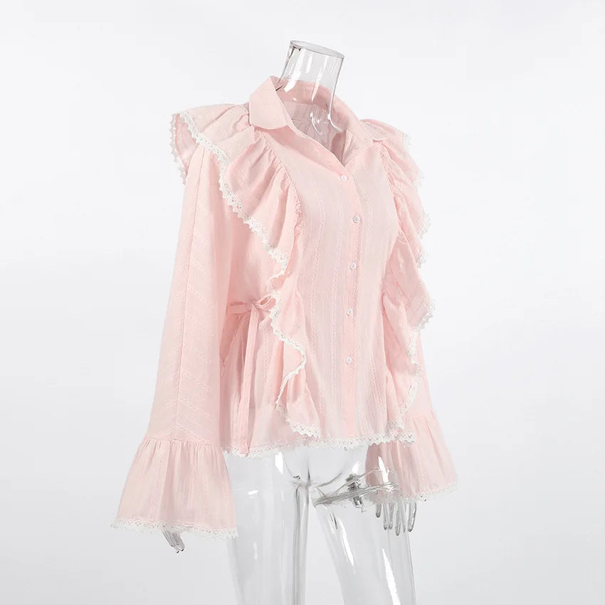 Pink blouse with ruffled details on a mannequin against a white background