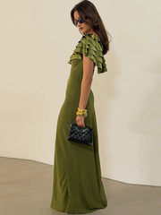 Side view of green O-neck sleeveless maxi dress with accessories
