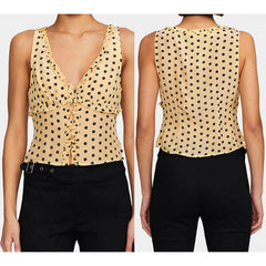 Yellow polka dot top worn by a model on a white background