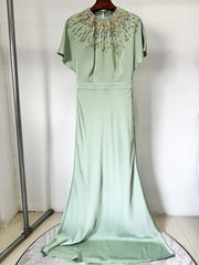 Mint green evening gown with beaded neckline on a white background