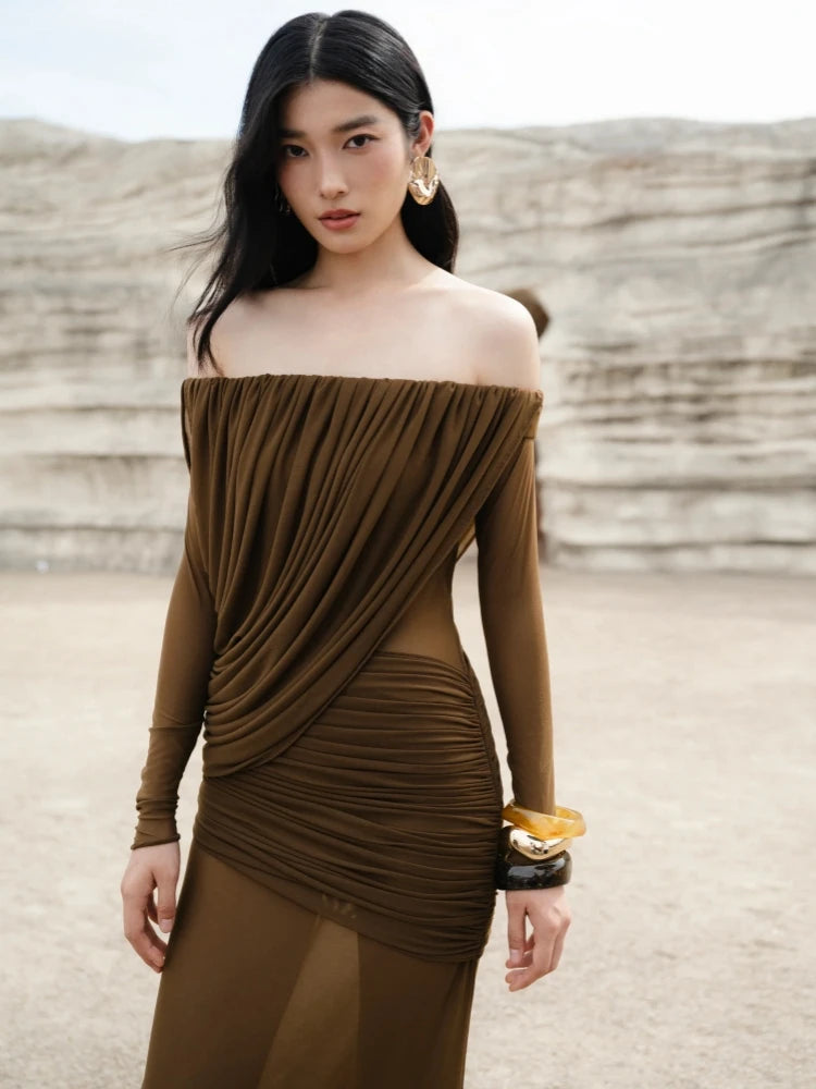 Woman wearing a brown off-shoulder dress in a desert setting