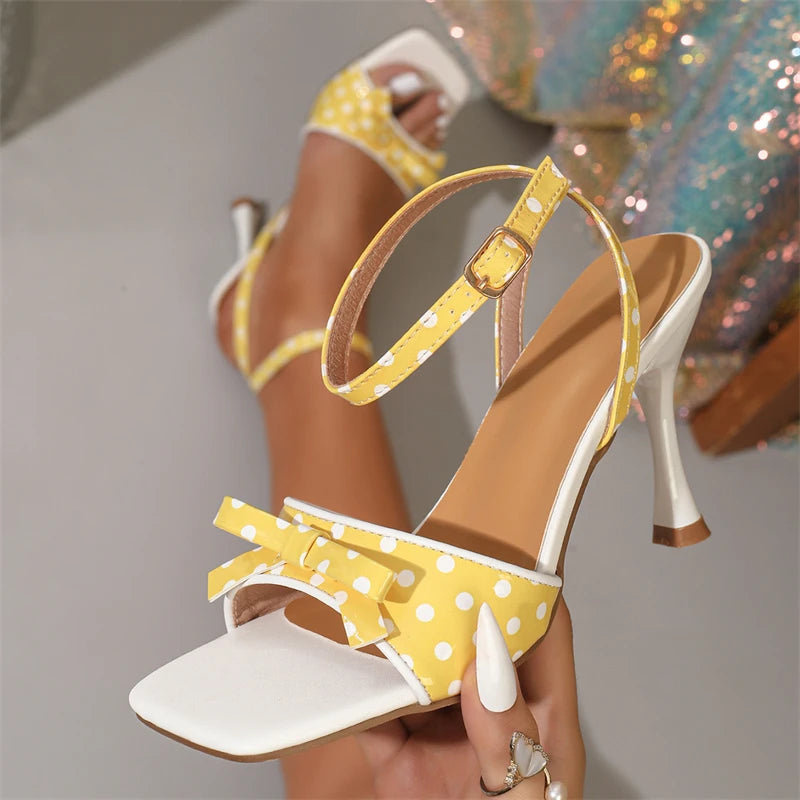 Close-up of yellow polka dot stiletto heels with bow