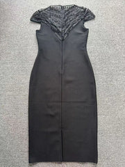 Flat lay of a black sheath midi dress with a beaded mesh yoke and cap sleeves.