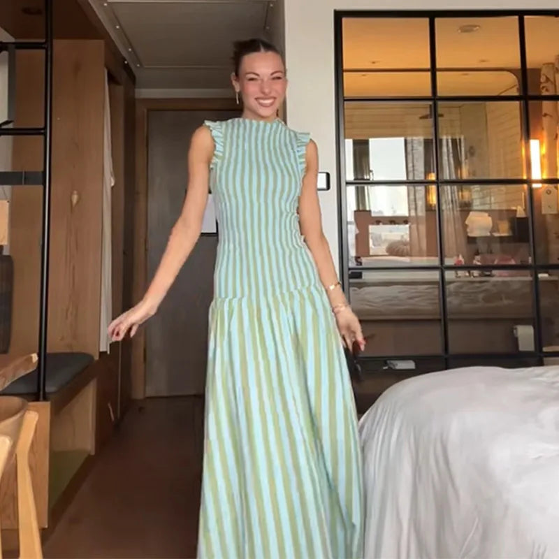 Sleeveless pleated dress styled indoors with relaxed summer vibe