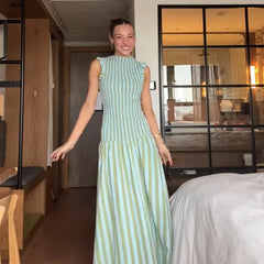 Sleeveless pleated dress styled indoors with relaxed summer vibe