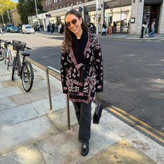 Woman in a patterned coat standing on a city street