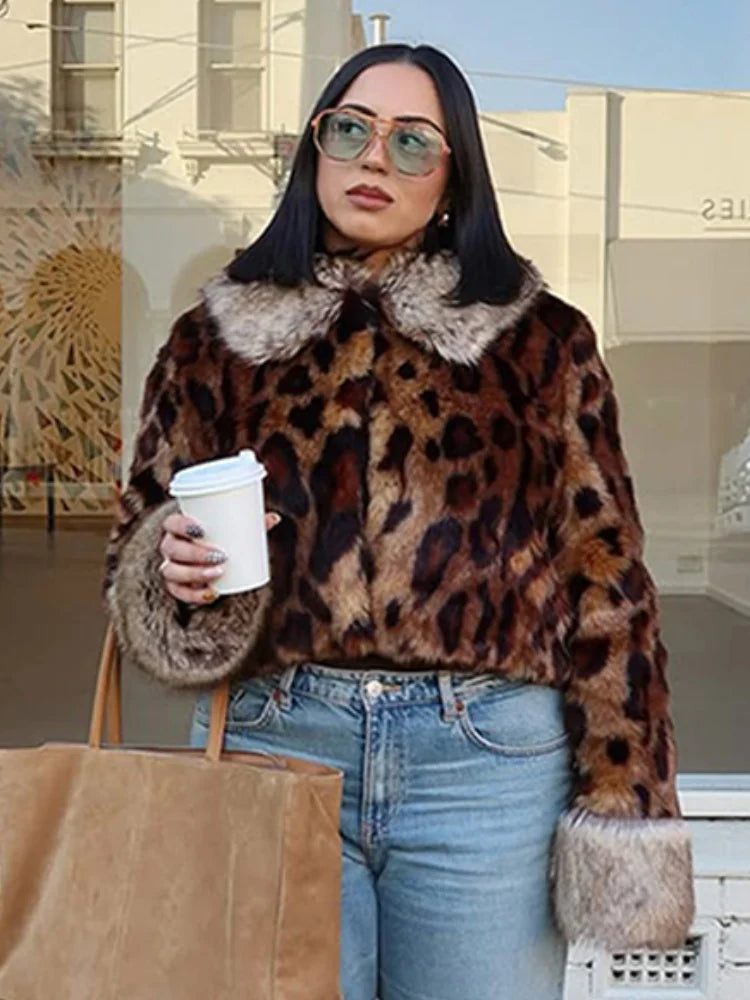 Person wearing a leopard print coat with fur trim, holding a coffee cup and a bag.