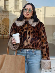Person wearing a leopard print coat with fur trim, holding a coffee cup and a bag.