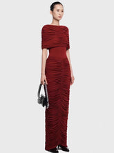 Straight-on silhouette shot emphasizing the sculpted drape and gathered detailing from bodice to skirt, styled for a formal evening.