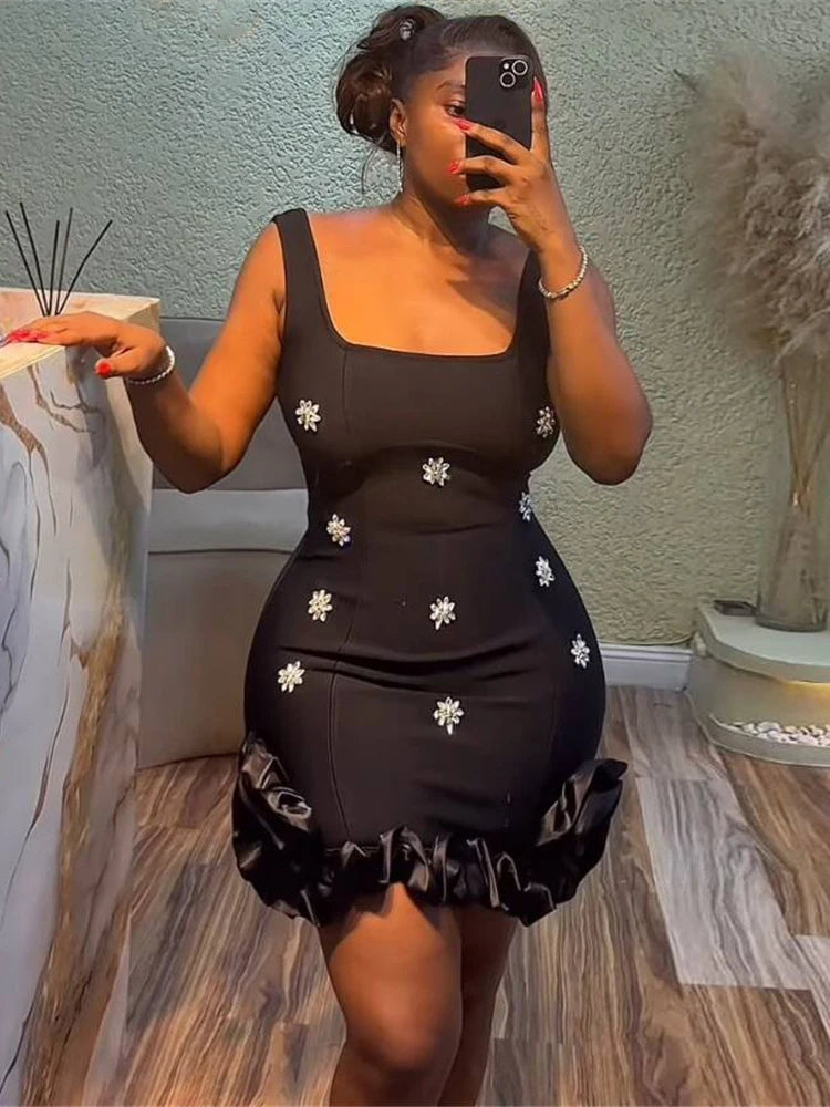 Woman taking a mirror selfie wearing a black applique diamond cocktail mini dress in light blue for summer events