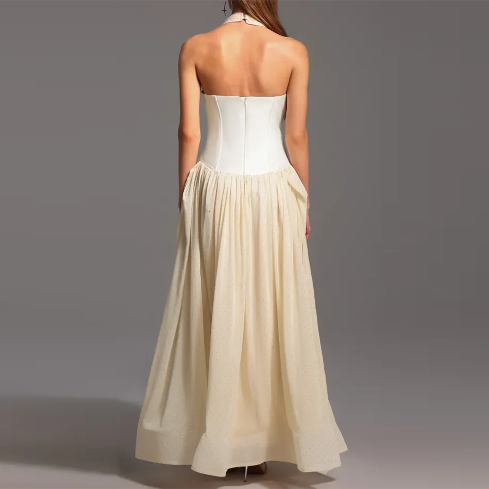 Back view of white corset and apricot pleated maxi dress on model