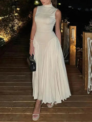Apricot pleated dress with high neck and flared skirt styled at night