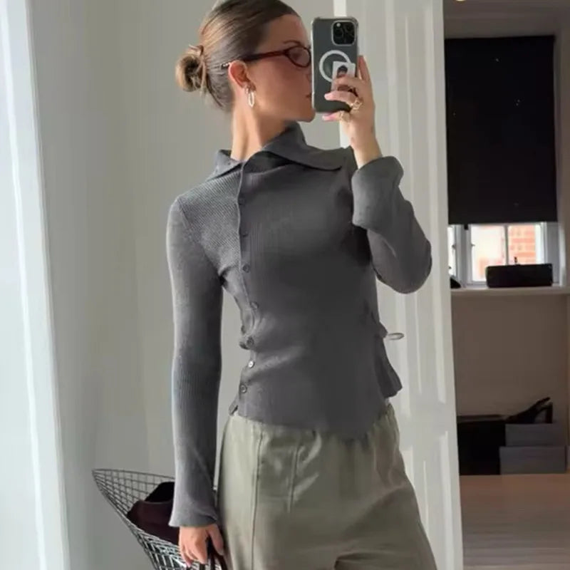 A woman wearing an asymmetric single-breasted cardigan in a chic, modern style.