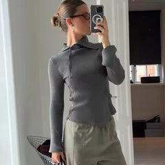 A woman wearing an asymmetric single-breasted cardigan in a chic, modern style.