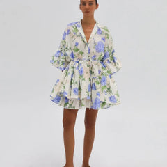 Woman wearing an elegant long-sleeve mini dress in blue and beige for work or weekend on a plain background.