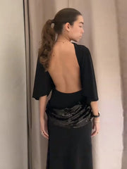 Back view of a black open-back mermaid dress, revealing the elegant cut and smooth fabric fall.