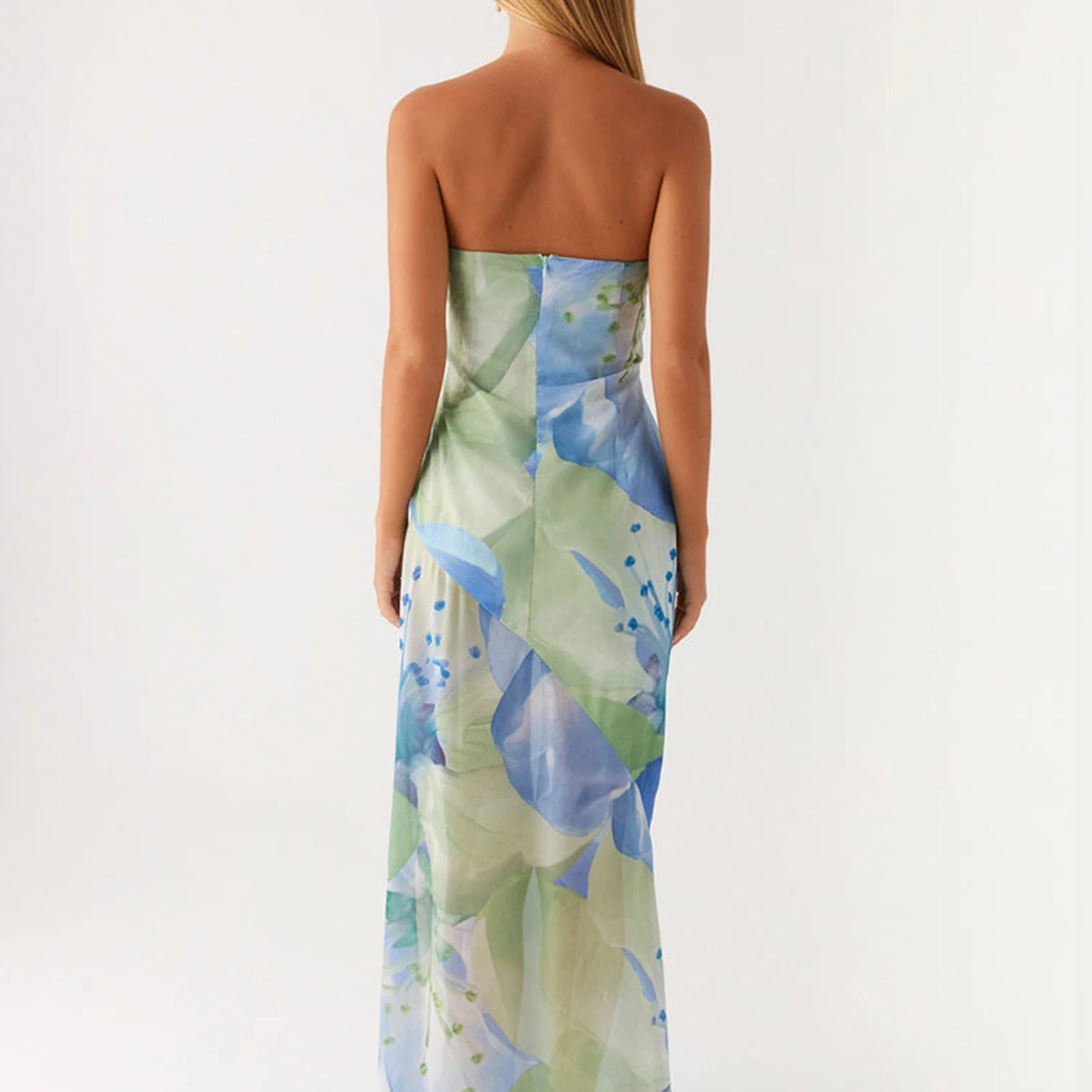 Woman wearing a strapless dress with a floral pattern on a white background backless view of sundress