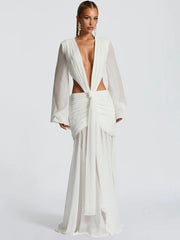 A woman wearing a backless white gown, perfect for destination wedding guests on a plain background