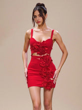 Woman wearing a red mini dress with 3D floral appliqué on a beige background