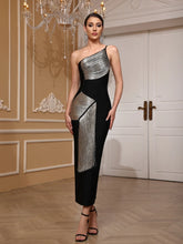 Woman in a Bandage midi evening party gown in black and silver, shown for celebrations, standing in an elegant room with a chandelier.