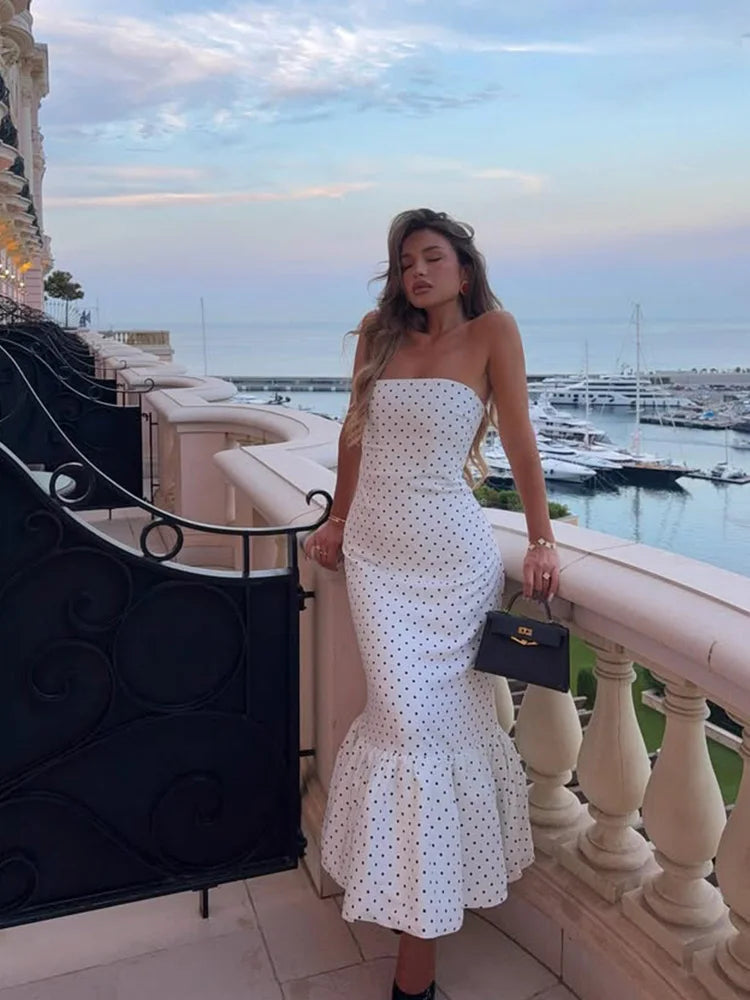 full length white polka dot strapless maxi styled with heels by the waterfront