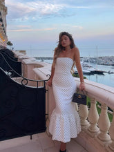 full length white polka dot strapless maxi styled with heels by the waterfront