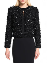 Model wearing a black beaded round neck jacket layered over a fitted dress against a clean studio background.