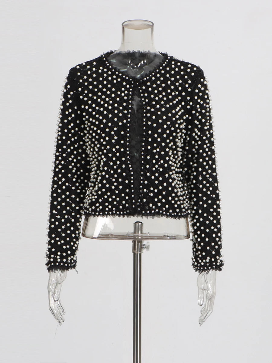 Detail view of the jacket sleeve highlighting structured drape and intricate beadwork.