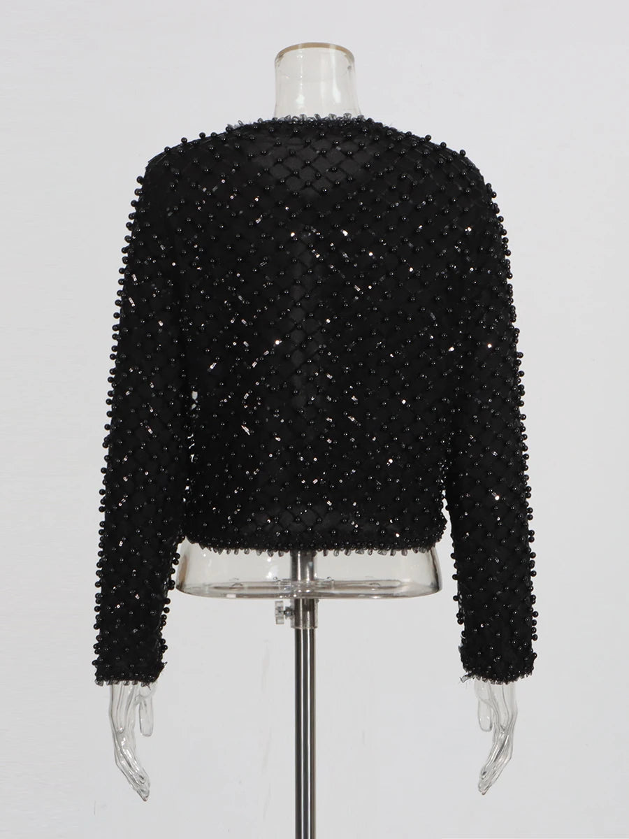 Black beaded jacket styled open for an elegant evening look with a streamlined silhouette.