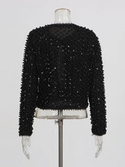 Black beaded jacket styled open for an elegant evening look with a streamlined silhouette.