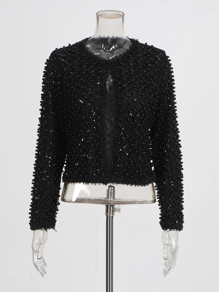 Close-up of the black jacket showing dense bead texture and refined surface detailing.