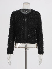 Close-up of the black jacket showing dense bead texture and refined surface detailing.