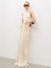 Close-up of the waist twist-knot and front cut-out detail on a beige maxi dress, showing gathered fabric and clean finishing.