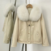 Beige suede down jacket with a white fox fur collar on a hanger.